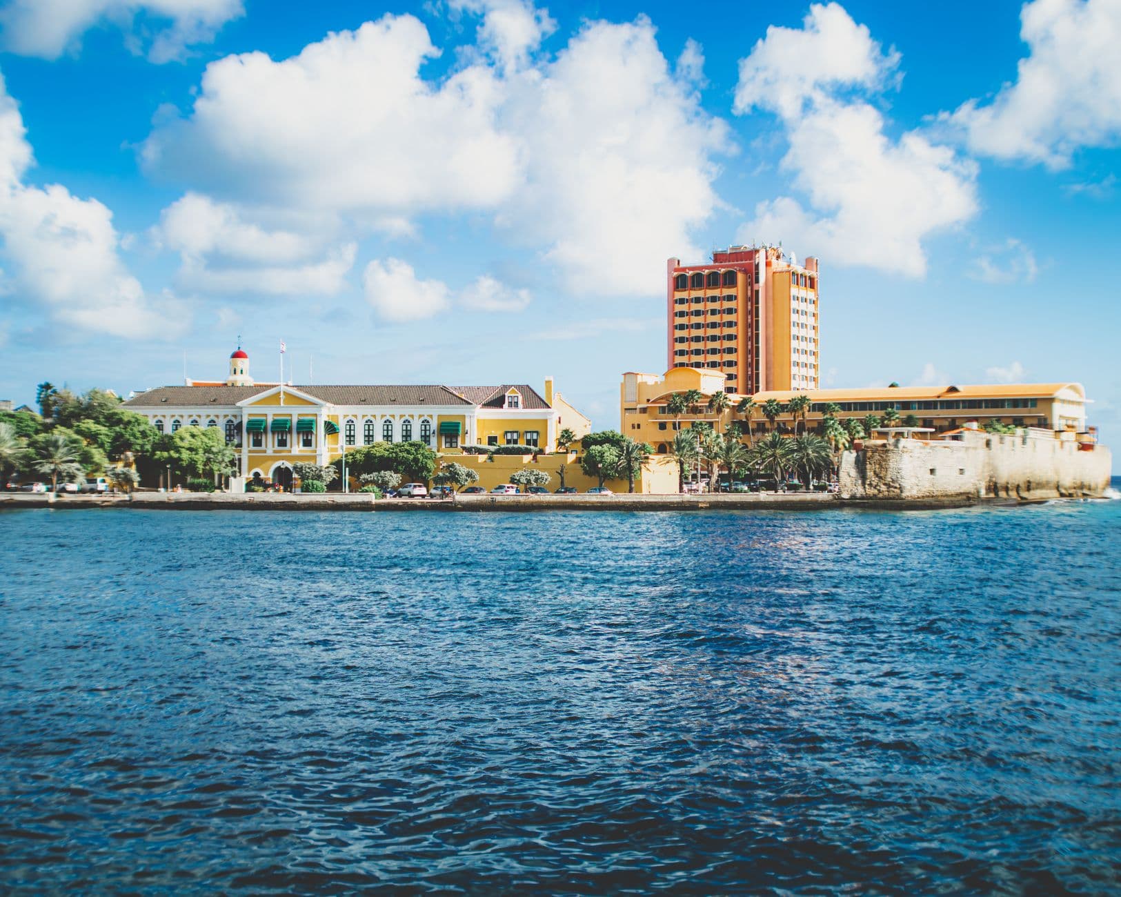 Het gouverneurspaleis en een hoog hotel aan de waterkant van Willemstad op Curaçao