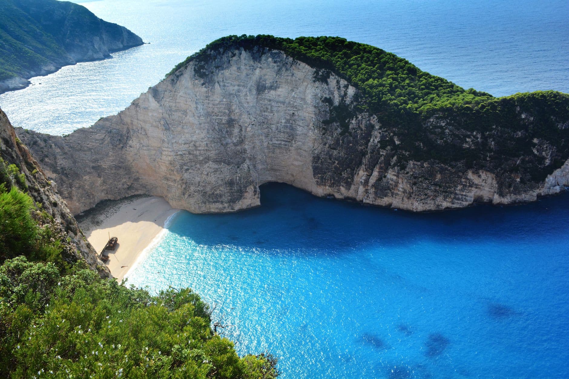 Zicht van bovenaf op de baai van Navagio op Zakynthos, met witte kliffen, turquoise water en het scheepswrak op het strand