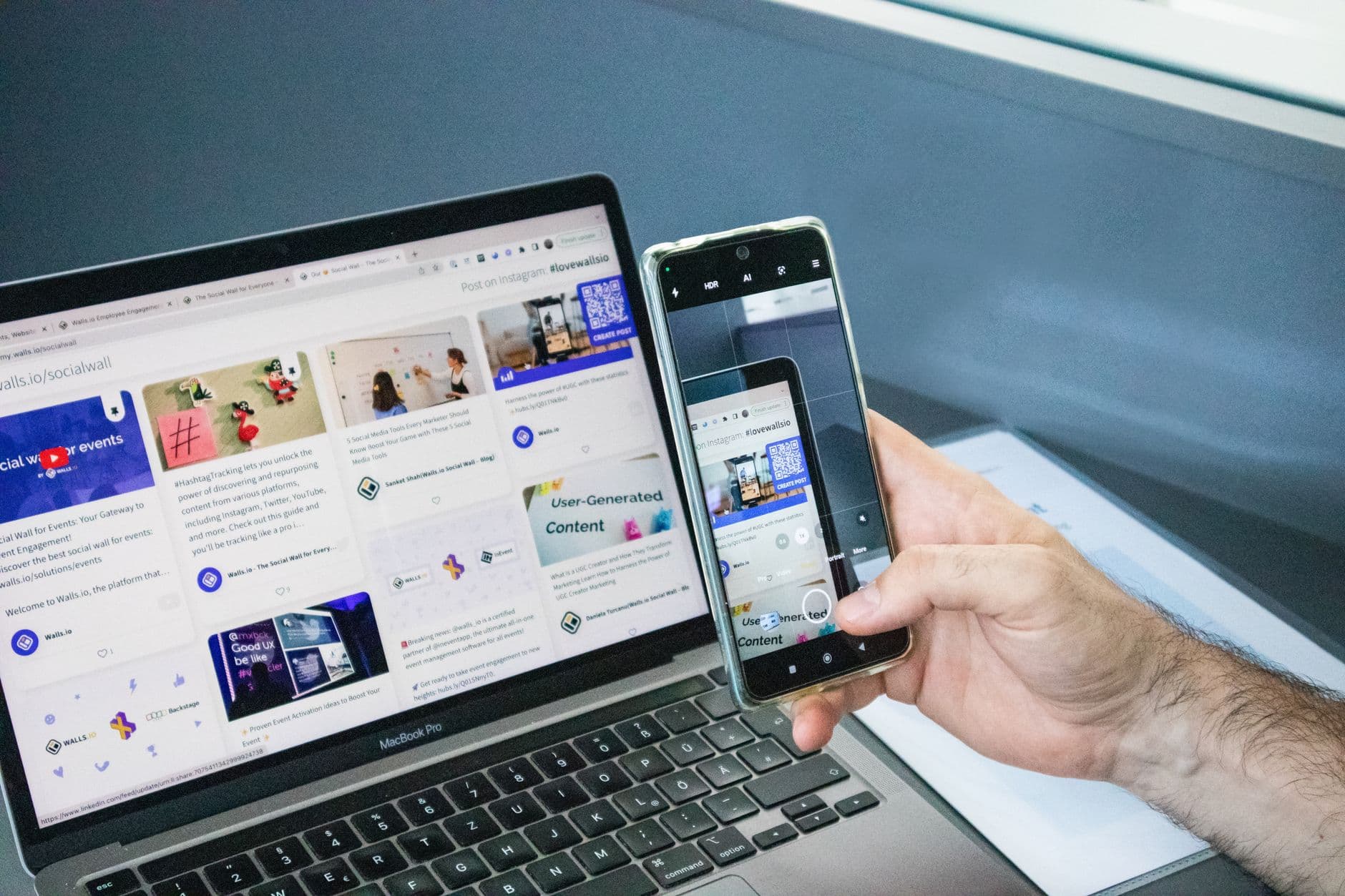 Close-up of a smartphone capturing a laptop screen, representing technology integration.