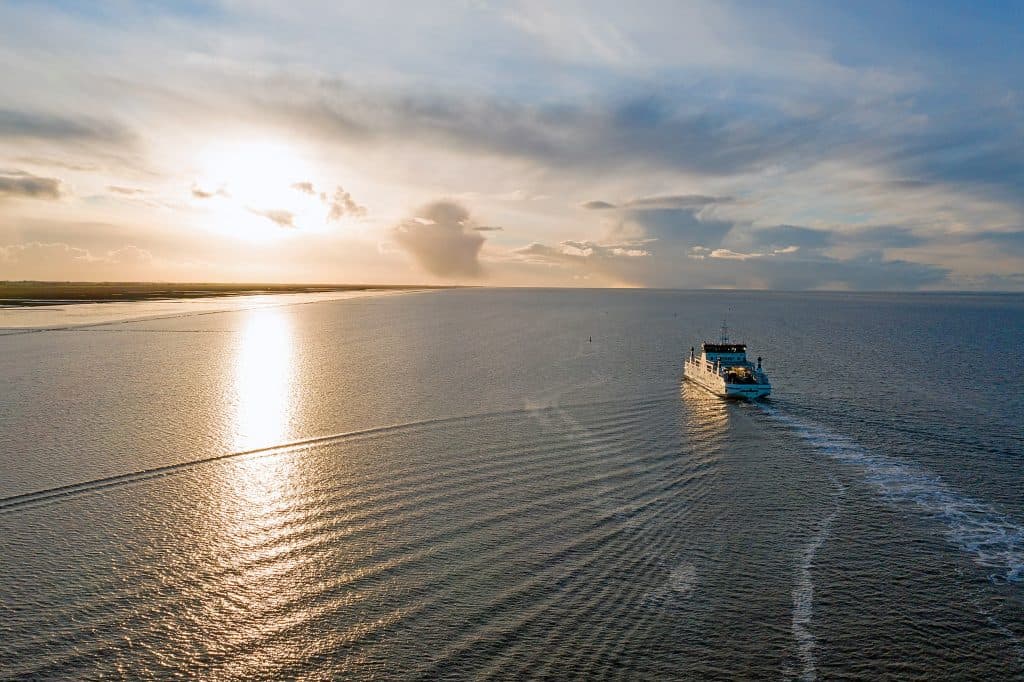 Een veerboot op zee bij zonsondergang.