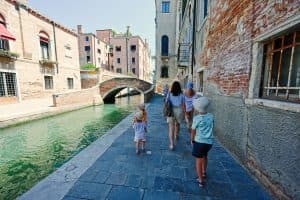 Moeder met kinderen loopt langs een kanaal in Venetië, Italië.