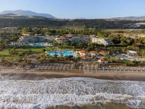 Luchtfoto van het Grand Palladium Sicilia Resort & Spa, gelegen aan de kustlijn van Campofelice di Roccella, Sicilië, Italië, met uitzicht op het hotelzwembad en de omliggende bergen